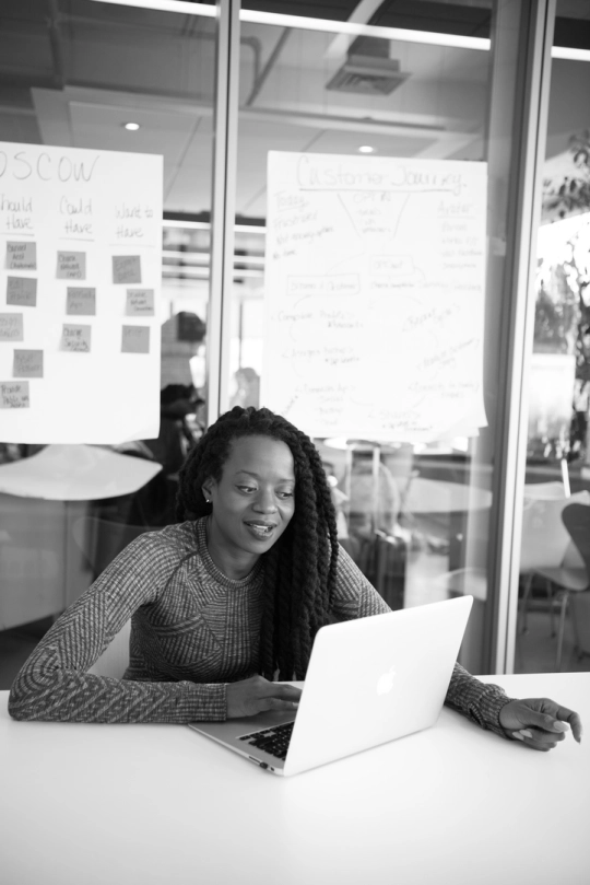 A woman working on a laptop in an office